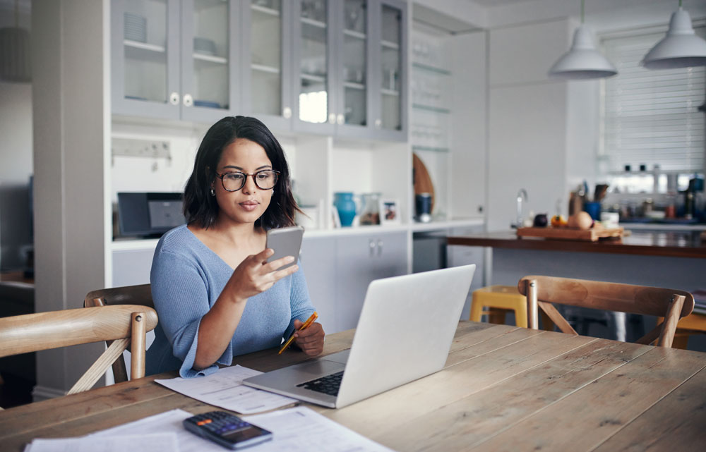 woman sitting at table with laptop open