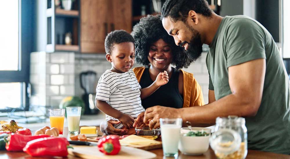 family in kitchen cutting vegetables