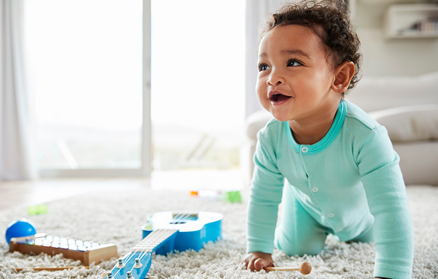 A baby boy happily playing with colorful toys spread out on the floor, surrounded by laughter and joy.
