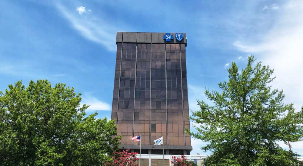 blue cross building with blue sky and trees