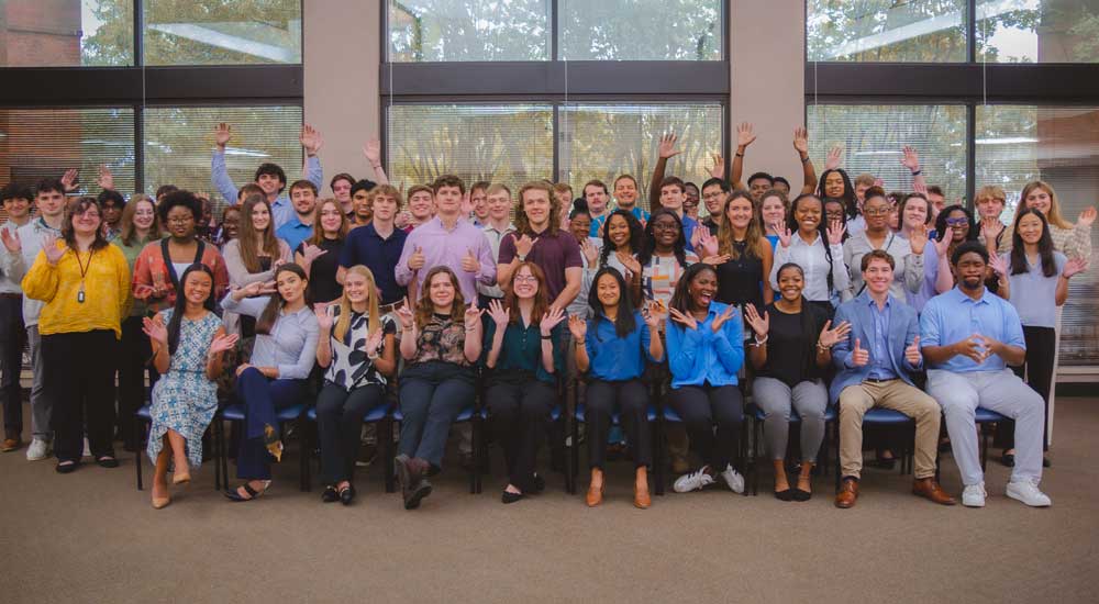 group photo of young people waving to camera