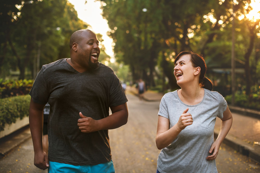 man and woman walking in park